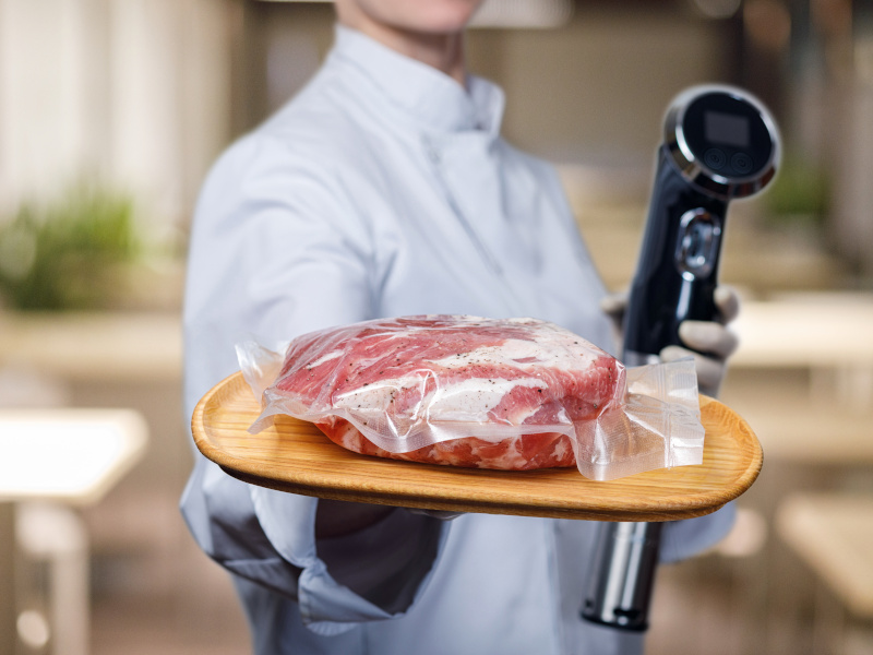 Shows cook sous vide immersion circulator cooker and the meat in the package.